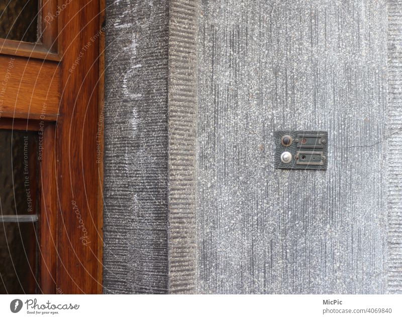 Vacant - empty doorbell sign on grey house wall with brown wooden door Vacancy vacant bell shield nameless Entrance Old Bell Exterior shot