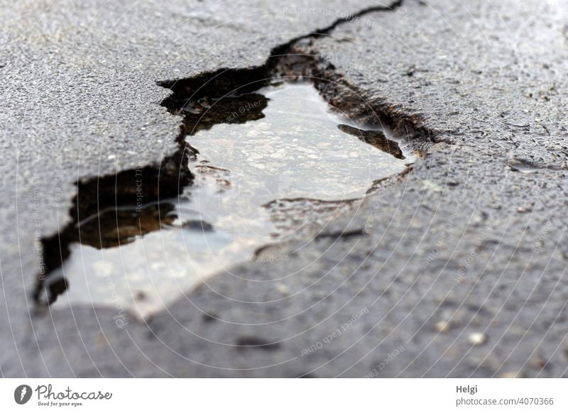big hole in the tar surface of the road, filled with rainwater road damage Hollow Broken corrupted Water Puddle Rainwater Risk of accident peril Street Damage