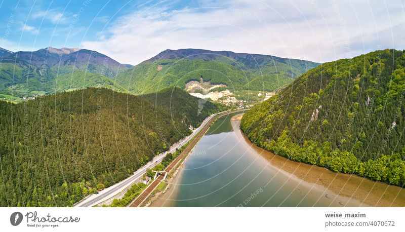 Village, river and road in mountain valley. Green mountain meadows and hills Tatra spring panorama landscape rain green Slovakia forest summer village railroad