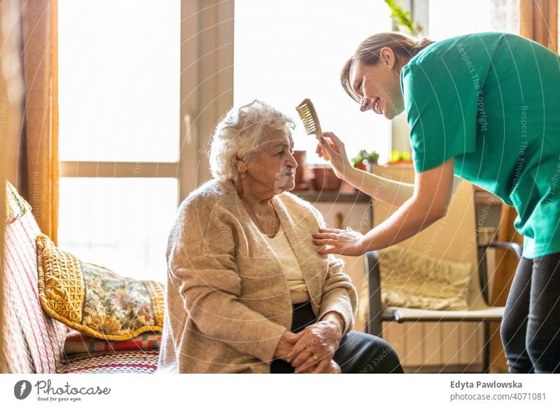 Female nurse taking care of a senior woman at home real people candid genuine mature female Caucasian elderly house old aging domestic life grandmother
