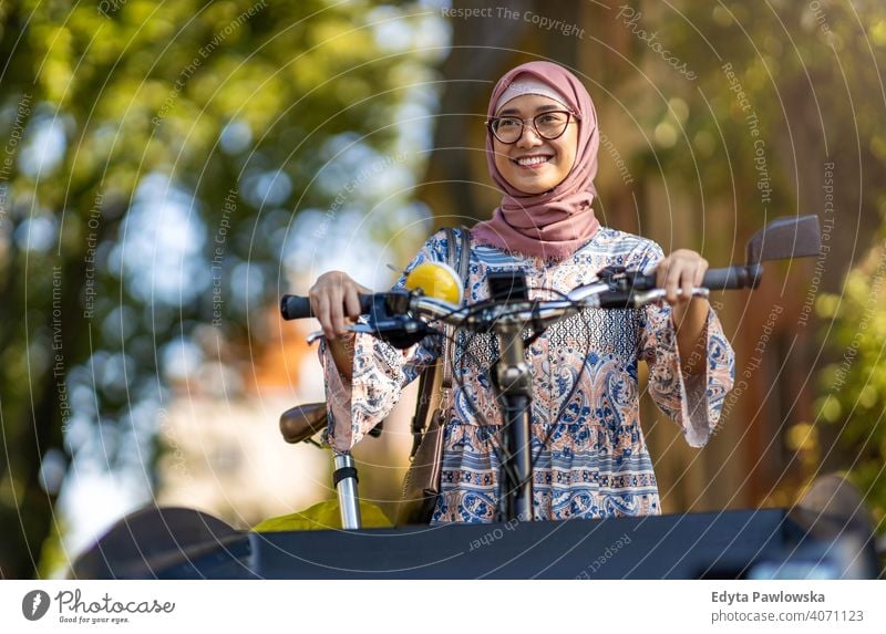 Confident Muslim woman using cargo bike in urban area hijab headscarf muslim islam arabic summer girl people young adult female lifestyle active outdoors