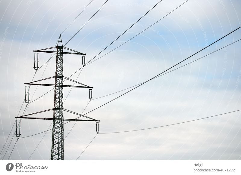Power pole with high voltage lines against cloudy sky Electricity pylon Power lines Energy High voltage power line Energy industry Technology Transmission lines