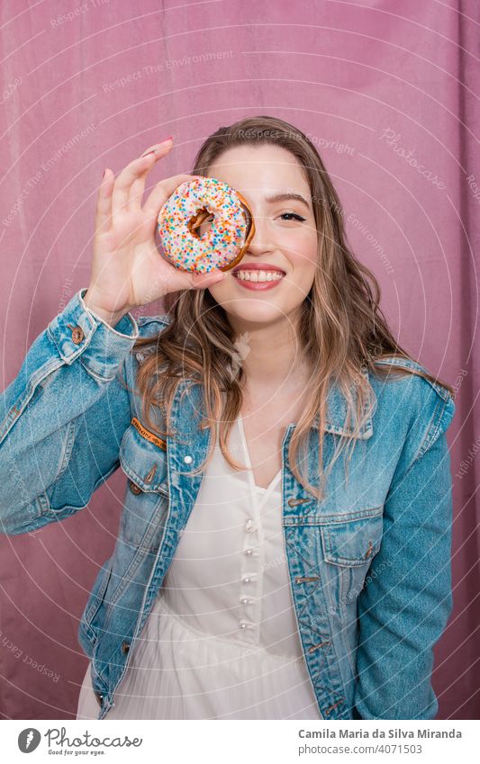 Beautiful woman holding a donut. attractive background bakery beautiful beauty cheerful colorful confectionery cute delicious dessert donuts doughnut easter eat