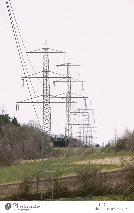 a row of metal power poles in the landscape in cloudy weather Fir pole Electricity pylon co2 high voltage Power lines energy Technology Cable Metal