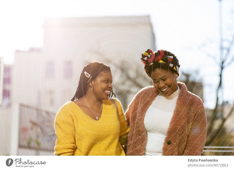 Beautiful happy girlfriends talking and smiling in city diversity diverse people love outdoors day positivity confident carefree woman young adult casual