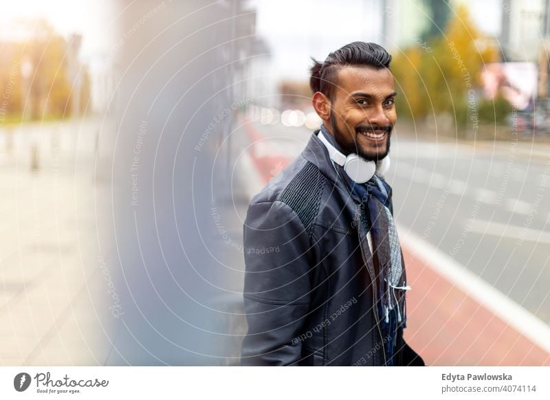 Portrait of a beautiful smiling man Indian ethnicity looking at the camera Sinhalese asian bearded outside street urban standing outdoors Warsaw one casual