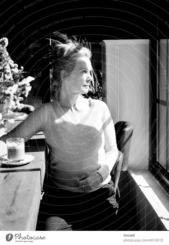 woman taking a break II blonde people black and white shadow flowers yellow coffee drink drinking interior local coffee shop cafeteria scene light restaurant