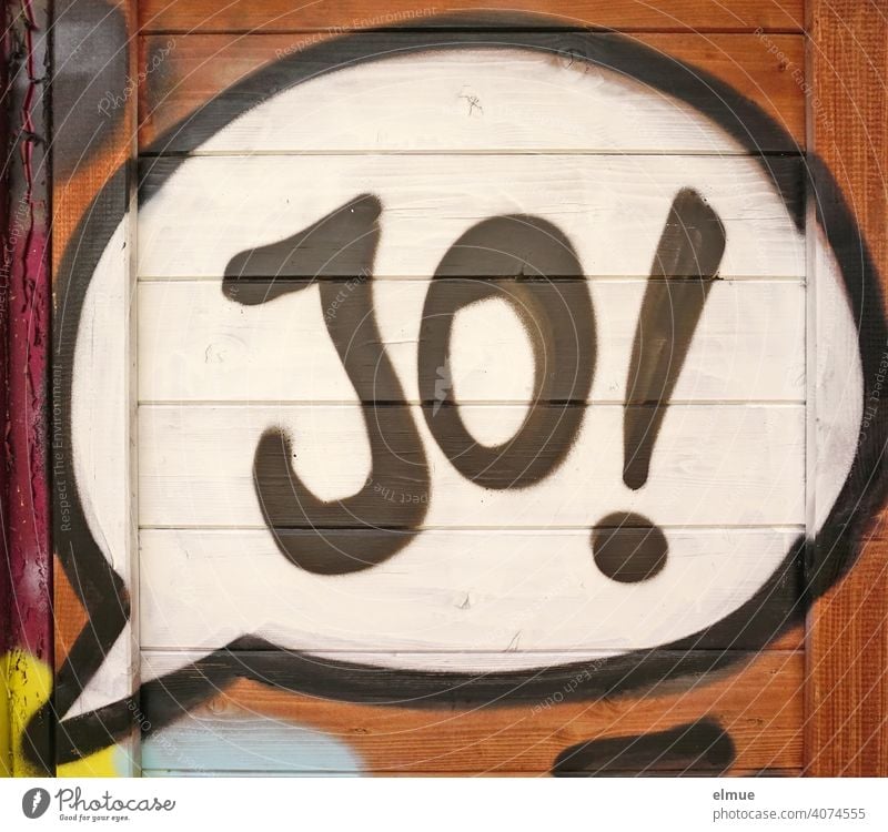 In the speech bubble of his graffito on the wooden wall the sprayer has written " Jo ! " written / think positive yo Yes Graffito Graffiti youth language