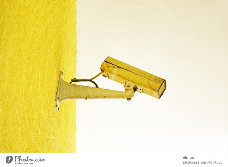 old, broken, yellow painted surveillance camera on a yellow wall / control / observation Surveillance camera Video surveillance Testing & Control Yellow