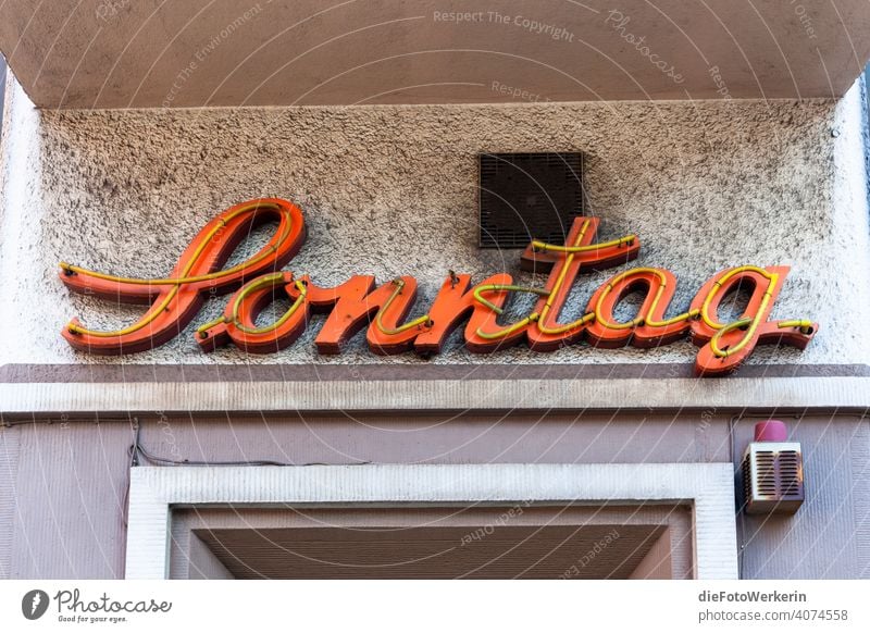 Illuminated advertising sign "Sunday Information Text Gray Orange Letters (alphabet) Characters Signs and labeling Deserted Word Colour photo writing Language