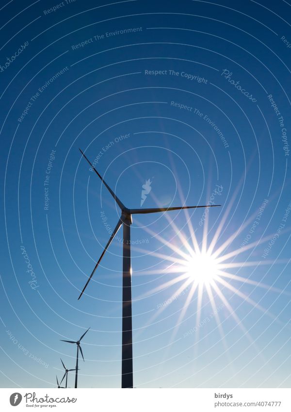 Wind turbine. Wind turbines for power generation in front of a blue sky with a bright sun Wind energy plant wind power windmills Cloudless sky Sunbeam