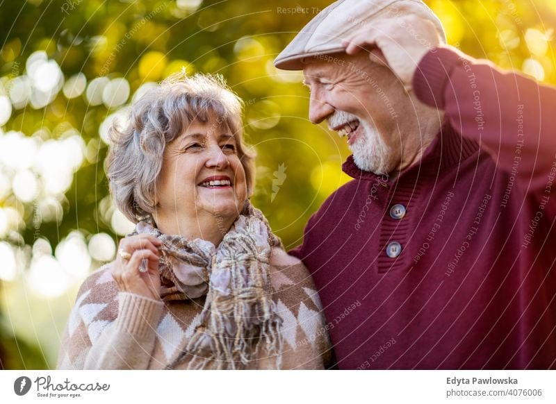 Happy senior couple enjoying a day outdoors in autumn love real people retired pensioner retirement aged grandmother grandparent grandfather two togetherness