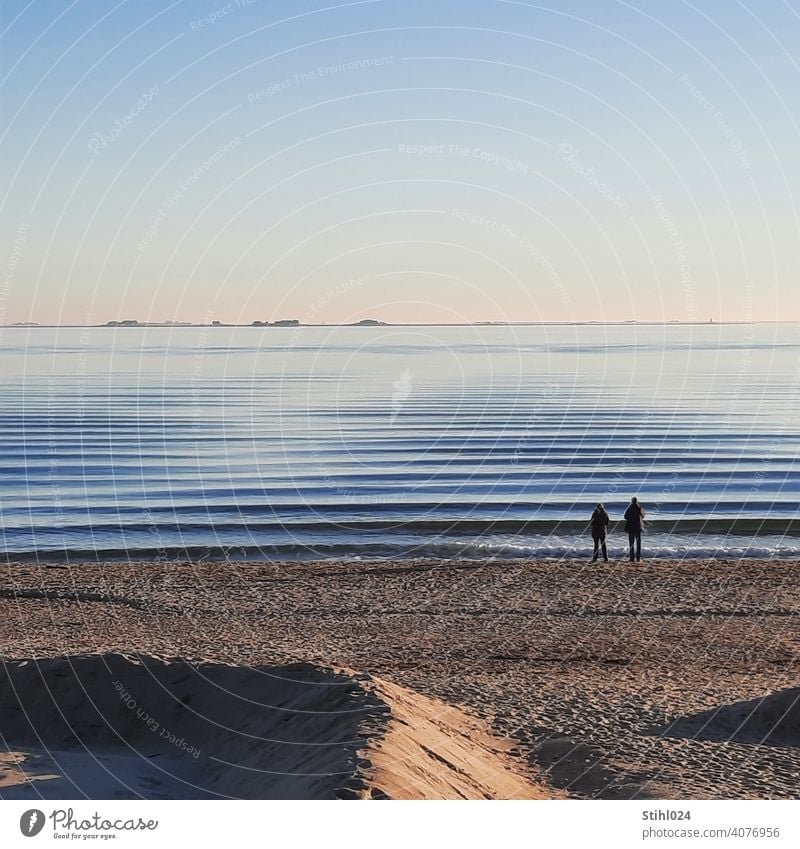 Couple on the beach of Föhr with view of the Halligen Beach Sandy beach Waves Swell swell Smooth ruffled Water Baltic Sea North Sea Fohr reverberant Island