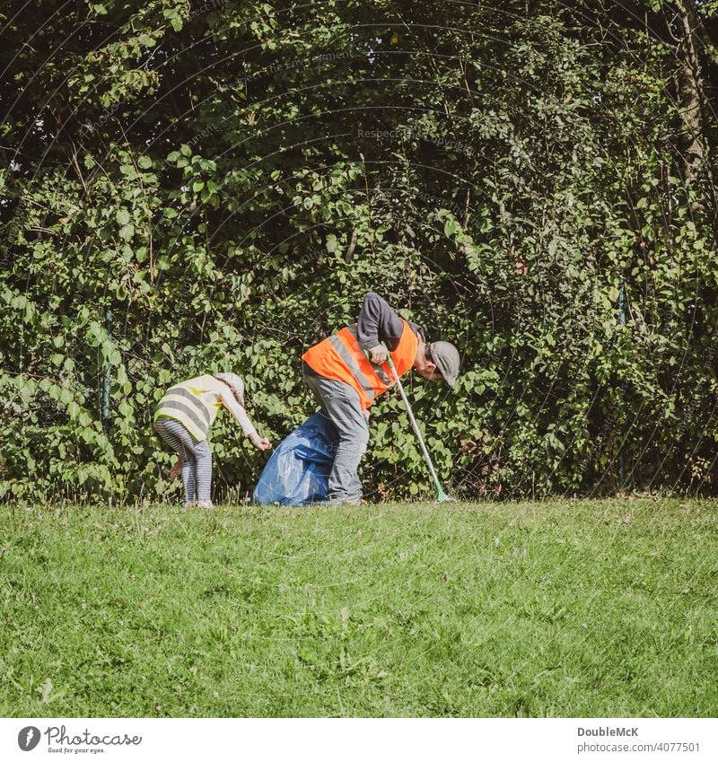 A man and a child search for trash in the bushes on World Cleanup Day clean up Action day social action Environment Trash September civic movement Eliminate
