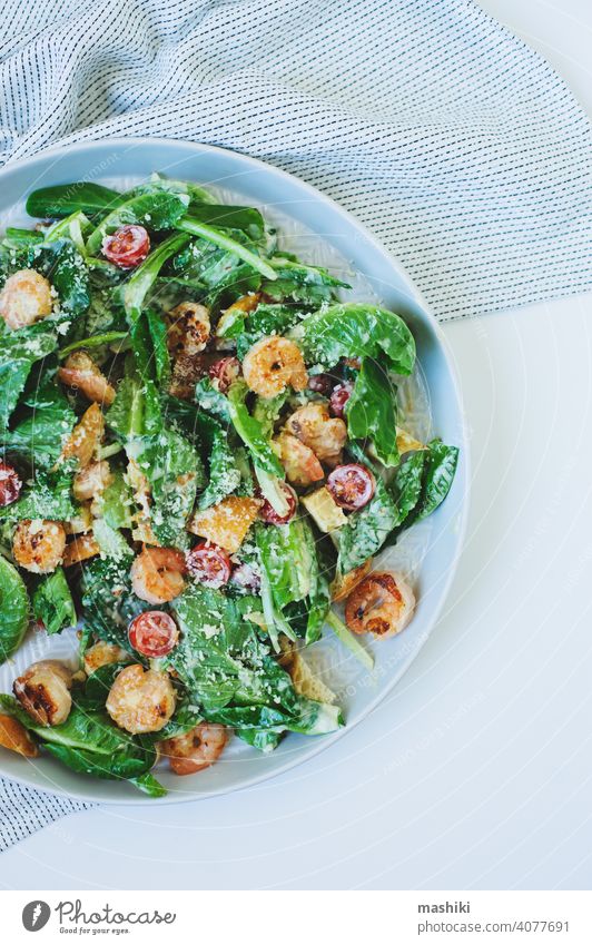 top view of tasty healthy salad with grilled shrimps, cherry tomatoes and crostini food lunch dinner vegetable meal green prawn seafood lettuce bowl fresh plate