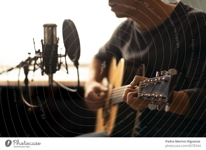 man playing spanish guitar and singing while recording it with a microphone musical instrument male person people human hat guitarist musician happy background