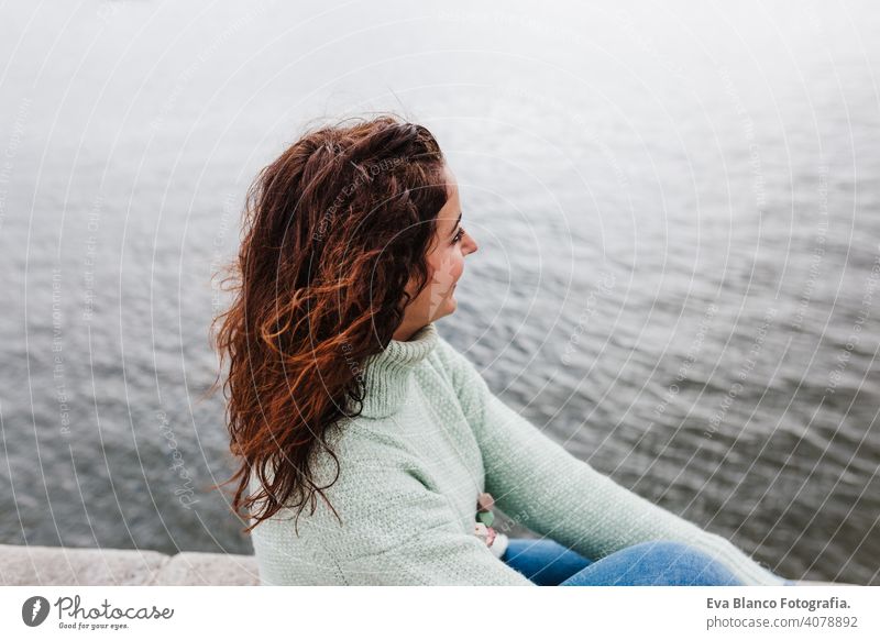 young beautiful woman sitting by the river at sunset enjoying Porto views. Travel concept travel city sightseeing urban caucasian people tour tourism spring