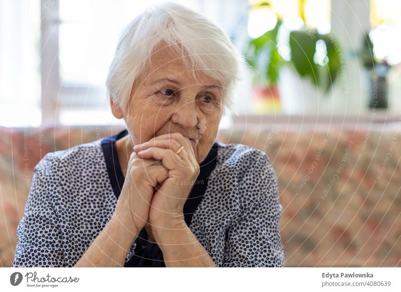 Portrait of an elderly woman in a state of worry at home sad lonely unhappy depression uncertainty anxiety worried grief sadness loss problem crisis serious