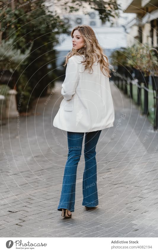 Charming lady posing on street woman city young urban lifestyle leisure sensual female denim trendy windy toothy joy elegant town casual gesture excited glad