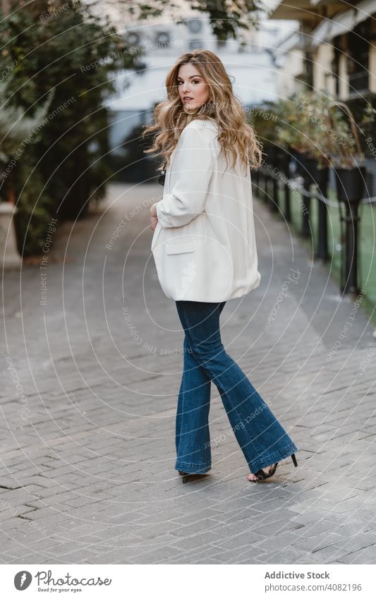 Charming lady posing on street woman city young urban lifestyle leisure sensual female denim trendy windy toothy joy elegant town casual gesture excited glad