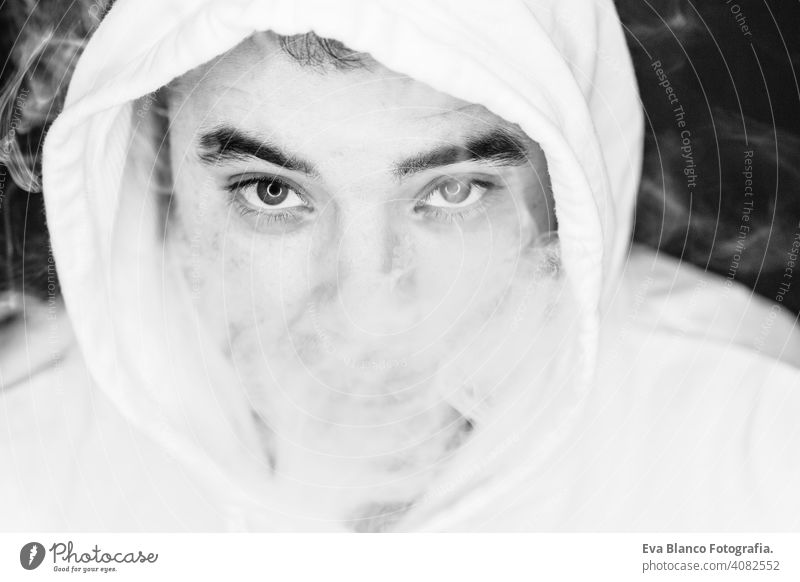 Portrait of a young man smoking, studio shooting, black and white , close up view.led ring reflection in the eyes head dark people male cigarette bad inhaling