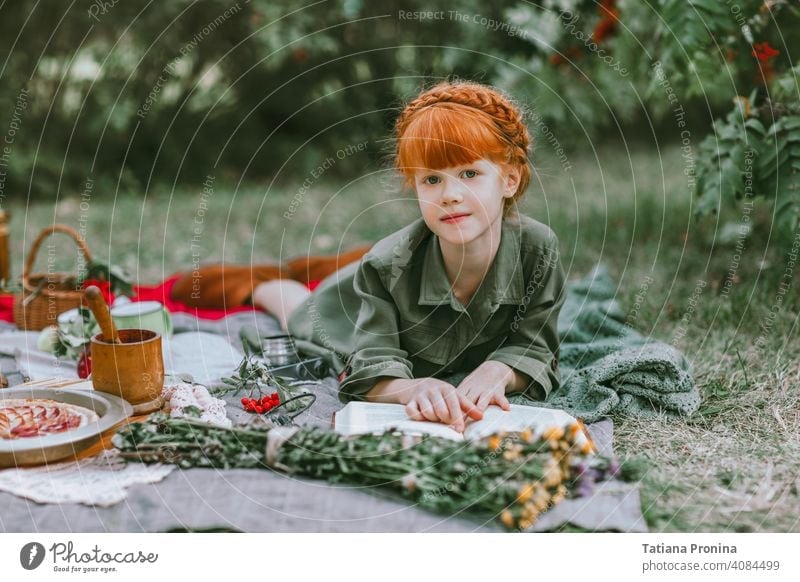 Red-haired little girl read book at retro picnic outdoor vintage hairstyle dress story tale study positive garden pretty reading blanket toddler life rest