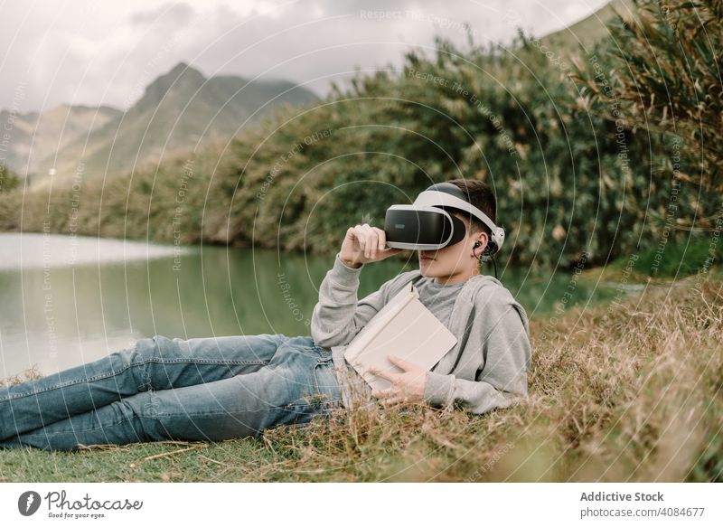 Young teenager with virtual reality glasses reading outdoors educational vr adolescent nature headset technology futuristic 3d young modern equipment