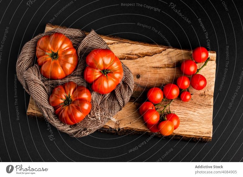 Tomatoes and napkin on wooden board tomatoes ingredient fresh ripe vegetable healthy food cloth fabric rustic vegan juicy tasty delicious yummy set composition