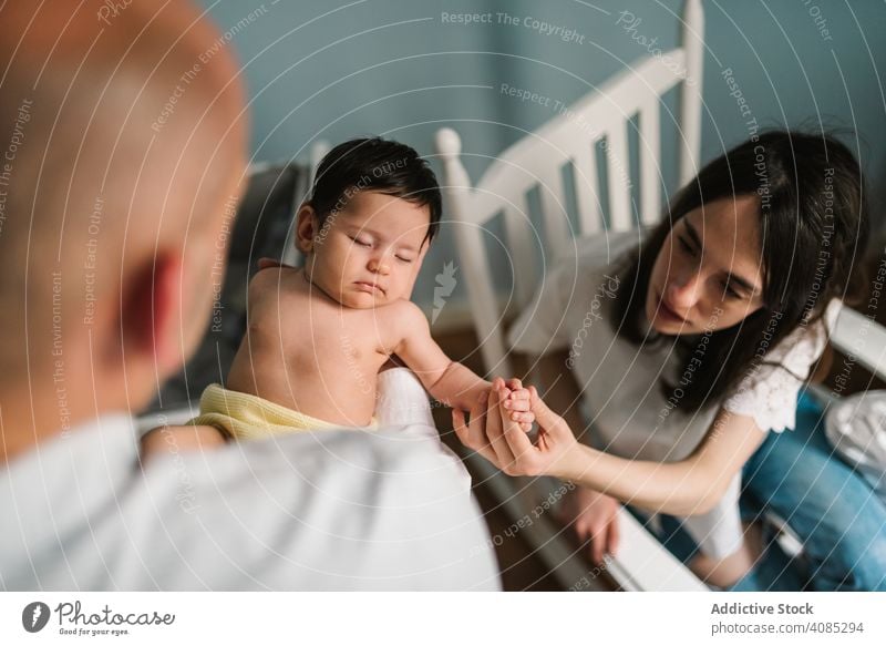 Parents holding baby in room parents touching care tender family love home bonding man woman mother father together joy newborn infant kid child speaking