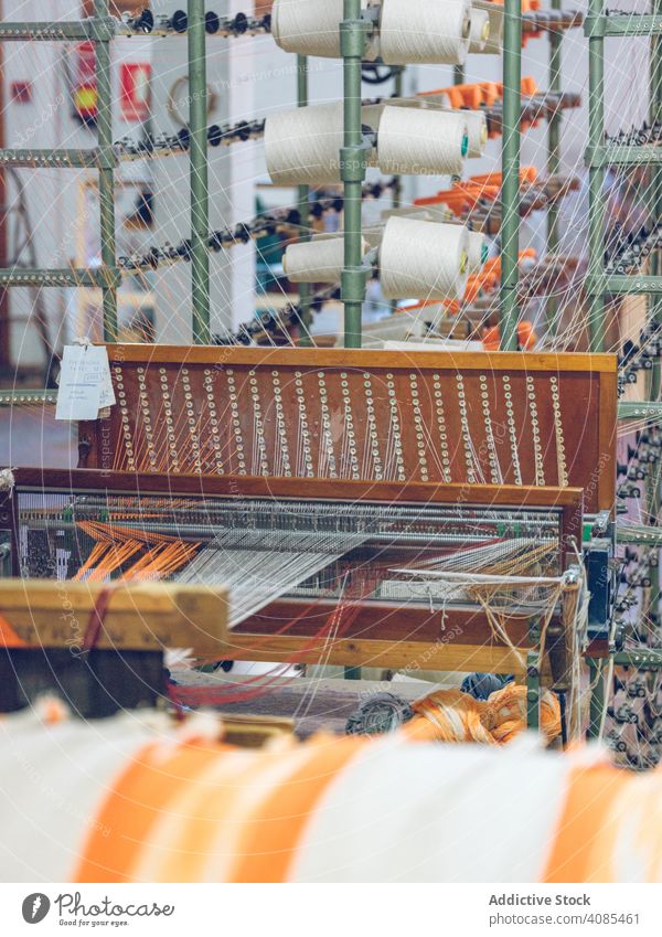 Spools of thread on weaver loom spools industry factory fiber cotton textile fabric machine manufacturing string craft yarn cloth orange bright color material
