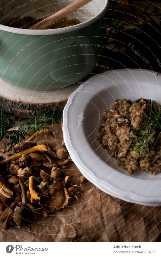 Rosemary on risotto with rabbit and mushrooms rice rosemary plate table kitchen rustic dish dinner food meat italian herb sprig healthy lunch meal traditional