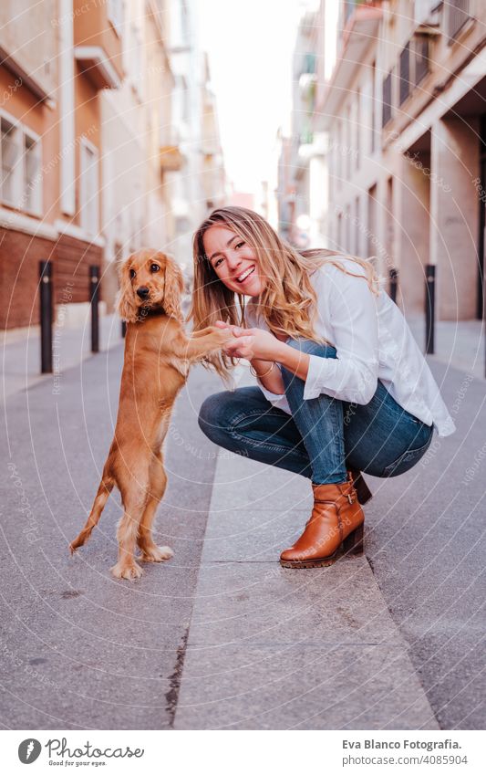 young woman at the street hugging her cute cocker dog. Lifestyle outdoors with pets walking city urban purebred caucasian coker lifestyle friendship beautiful
