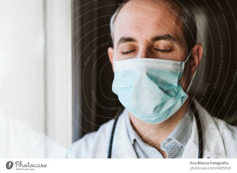 portrait of doctor man by the window wearing protective mask and gloves indoors. Corona virus concept professional corona virus hospital working infection