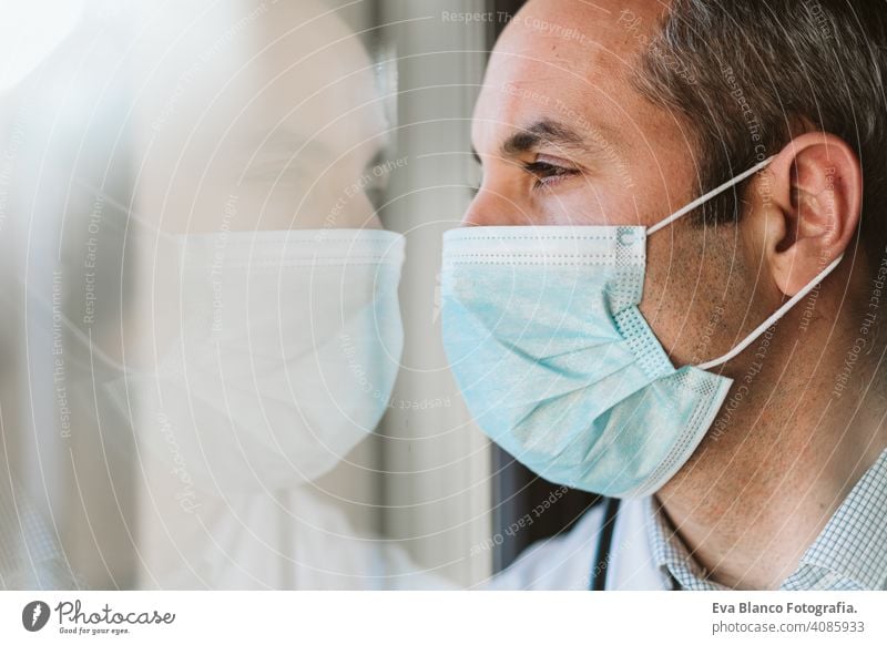 Close up of female UK NHS EMS doctor's face,wearing blue PPE surgical  protective mask,COVID-19 Coronavirus disease,global pandemic  outbreak,deadly SARS-CoV-2 epidemic,copy space on left side of frame - a  Royalty Free Stock Photo