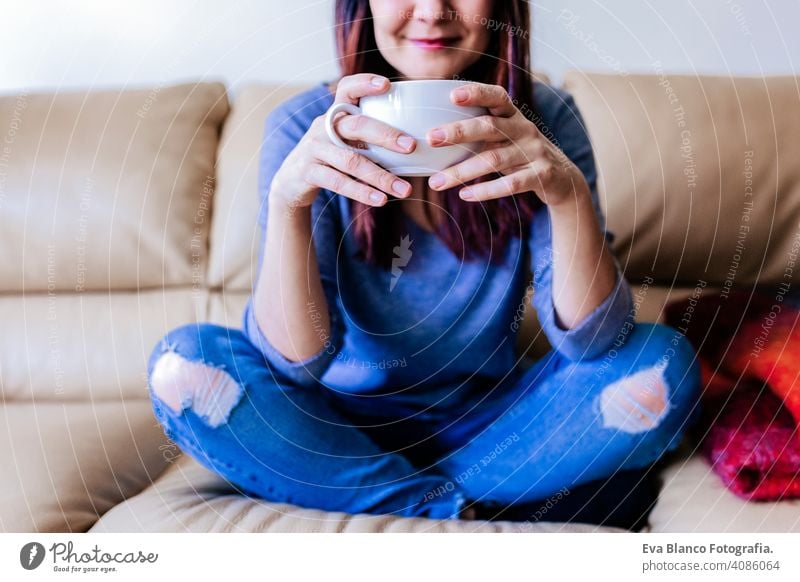 young caucasian woman having coffee or tea at home for breakfast at home. Close up view living resting lifestyle leisure indoors person sitting hot smiling