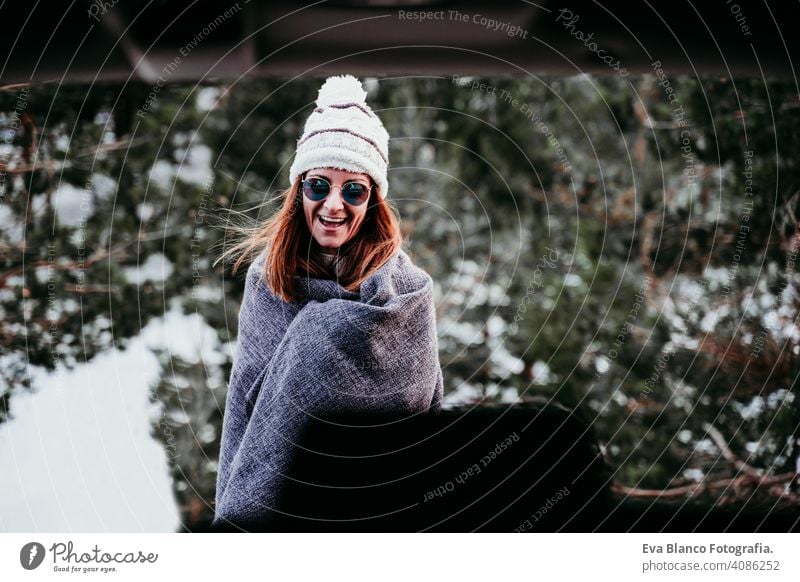 portrait outdoors at the mountain of young woman wearing winter clothes snow forest hat blanket modern relax nature enjoy green cold hipster car wanderlust one