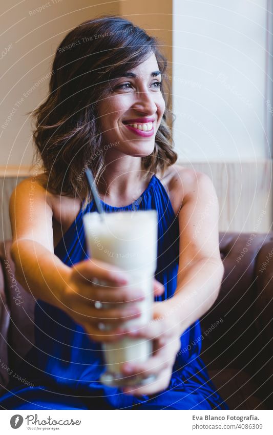 young beautiful woman enjoying a smoothie drink in a cafe. Casual blue dress. Modern life indoors. selective focus using person attractive business rest cute