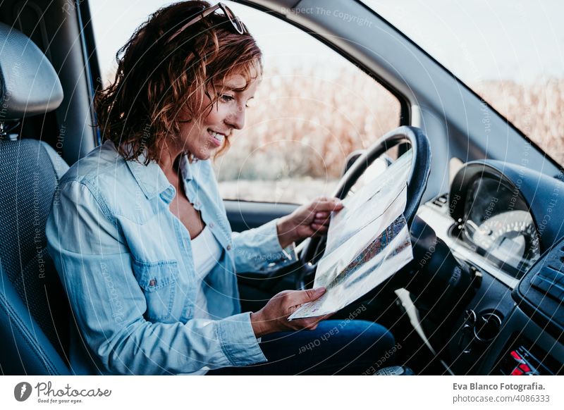 young beautiful woman reading a map in a car. travel concept driving sunny sunglasses traveling wheel drive hire sharing new traffic maintenance expensive