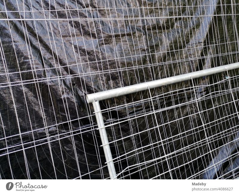 Construction fence with grey wire mesh and black plastic privacy screen on a construction site on the campus of Goethe University in Frankfurt am Main Bockenheim, Hesse