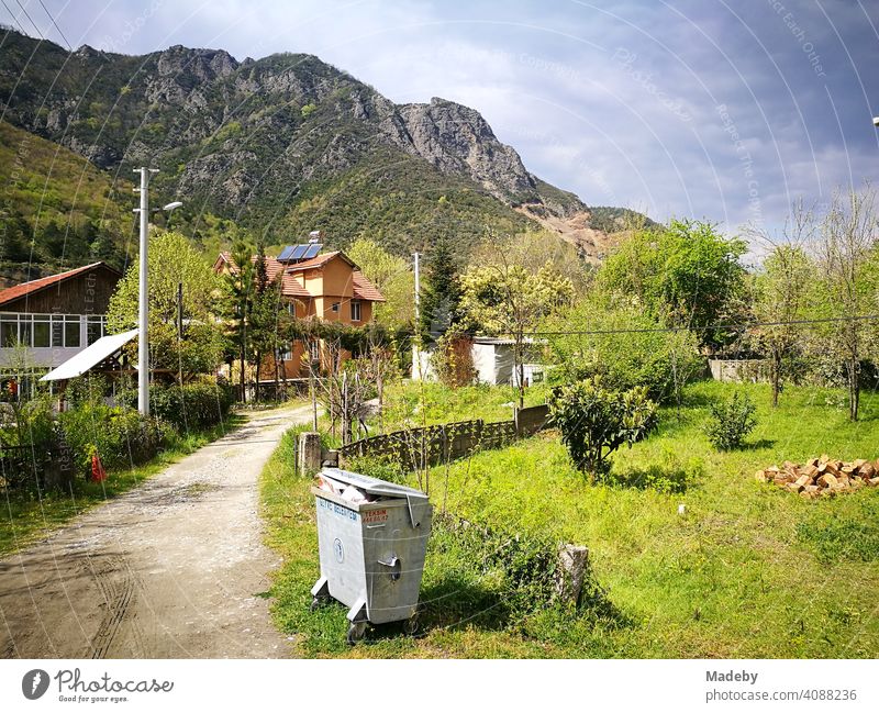 Full garbage can in the village of Dogancay in the mountains near Adapazari in the province of Sakarya in Turkey in summer sunshine Village Landscape Province