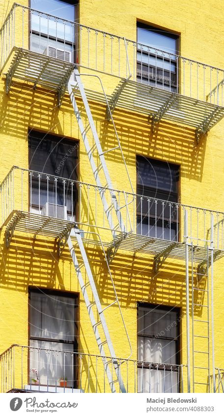 Old yellow building with iron fire escape, New York City, USA. city Manhattan old architecture house facade stairs NYC ladder residential urban America exterior