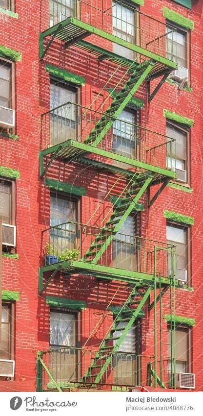 Old red brick building with green iron fire escape, New York City, USA. city Manhattan old architecture stairs house apartment facade NYC ladder residential