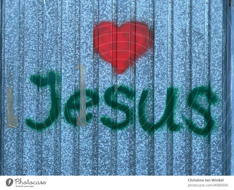 Graffiti with the name Jesus and a red heart on a metal facade Heart Love metal wall Red Easter Holy Week Belief Hope Church Jesus Christ Religion and faith
