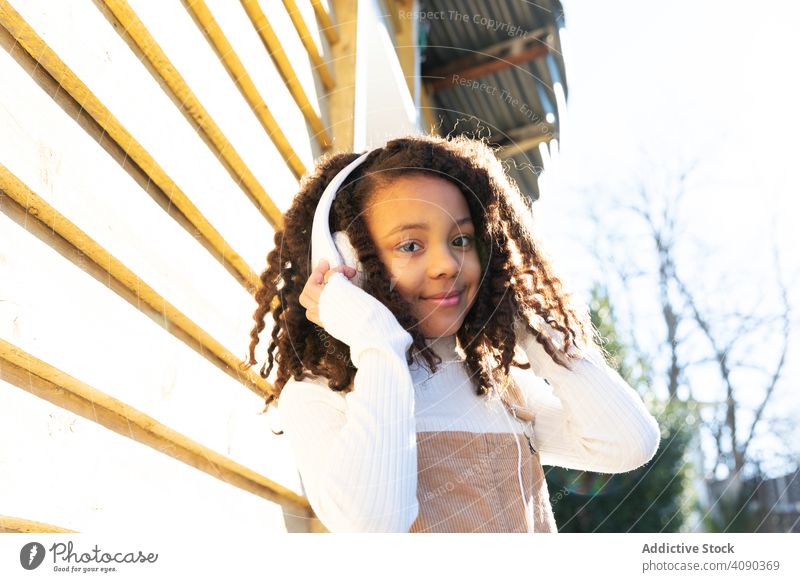African-American girl listening music with headphones african american black happy young beautiful pretty attractive people lifestyle standing technology