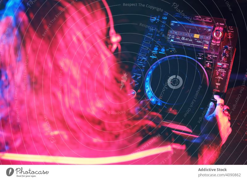From above an anonymous dj man playing in a club with lights nightclub hand entertainment record equipment turntable party disc background dance lifestyle house
