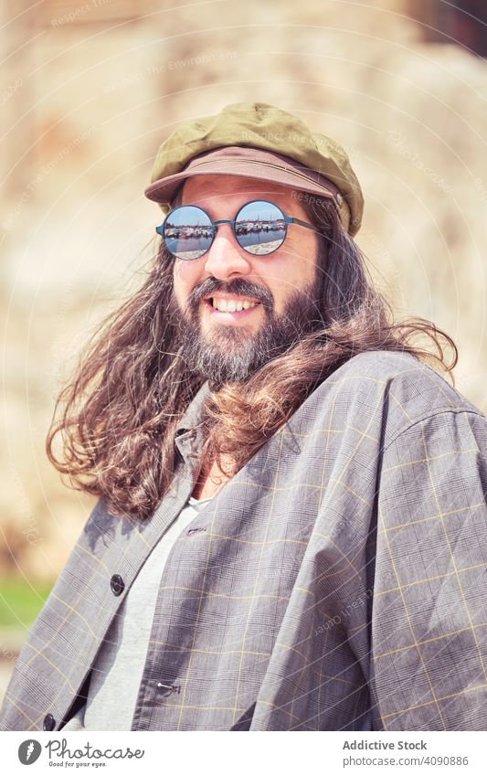 stylish bearded man with long hair sitting on street with sunglasses trendy mustache portrait guy looking cool handsome urban fashionable model attractive