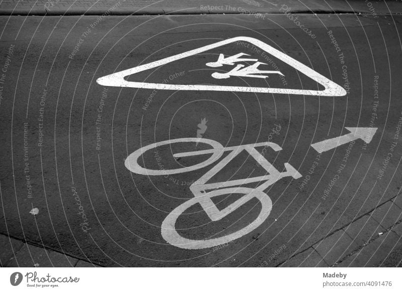 Painted notice for car drivers and cyclists on school children on grey asphalt in the Mathildenviertel in Offenbach am Main in Hesse, photographed in neo-realistic black and white