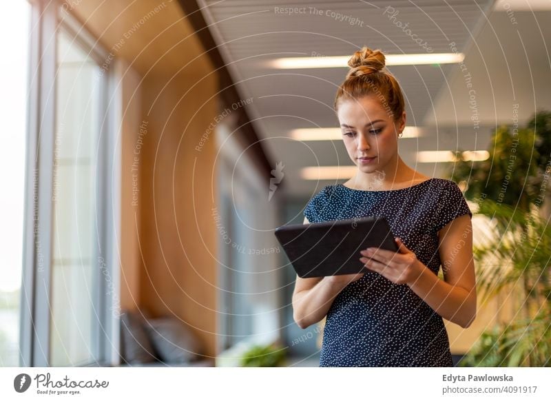 Young businesswoman using digital tablet in her office girl people Entrepreneur successful professional young adult female lifestyle indoors millennial