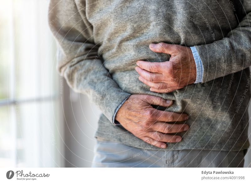 Senior man with stomach pain stomachache belly abdomen abdominal pain reflux food poisoning Gastroesophageal Reflux Disease cramp symptom intestine hands