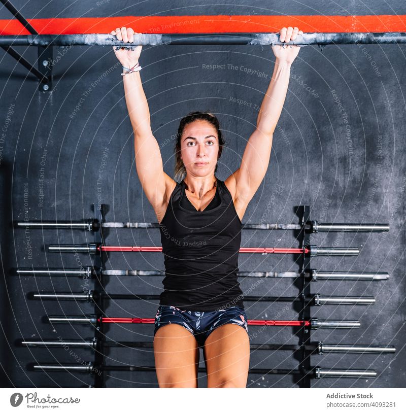 Hardworking female training in gym woman pull-up strong hardworking bar weight exercise fitness workout sport strength athlete muscular equipment young healthy